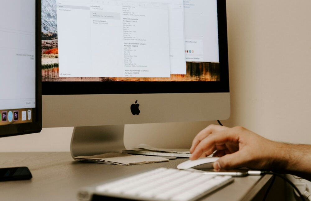Photo by Kaleidico person holding white Apple Magic Mouse beside iMac and keyboard