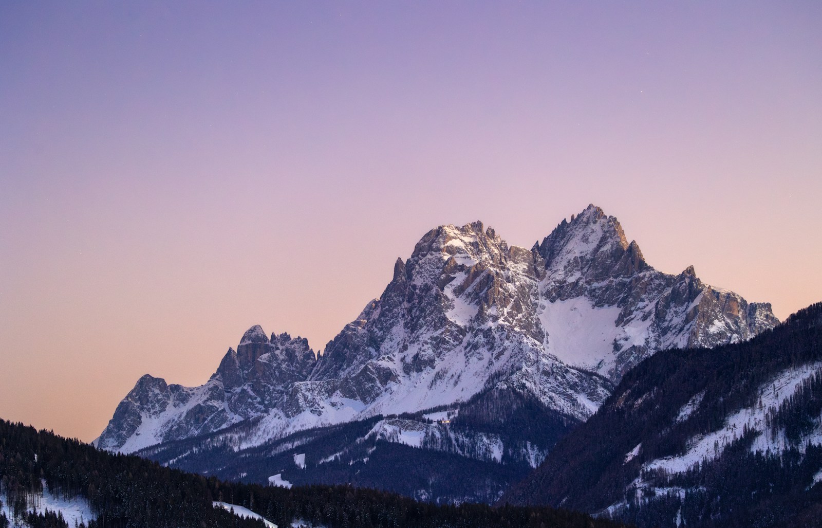 Photo by Marek Piwnicki Snow-capped mountains against a colorful sky.